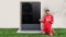 Das Bild zeigt Thomas Müller mit dem Smartphone in der Hand vor der Vitocal 