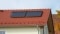 Das Bild zeigt ein rotes Hausdach, auf dem eine Solarthermiekollektoren befestigt sind.