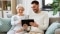 Frau und Mann sitzen mit Tablet auf dem Sofa